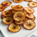 crispy air fryer banana chips seasoned with cinnamon on a white plate