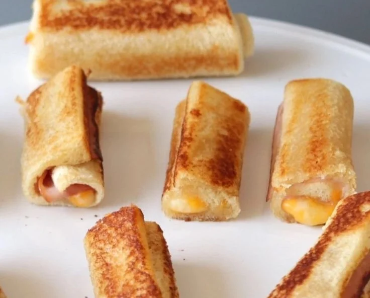 Grilled Cheese Roll-Ups on a plate, golden and crispy, with cheese oozing out.