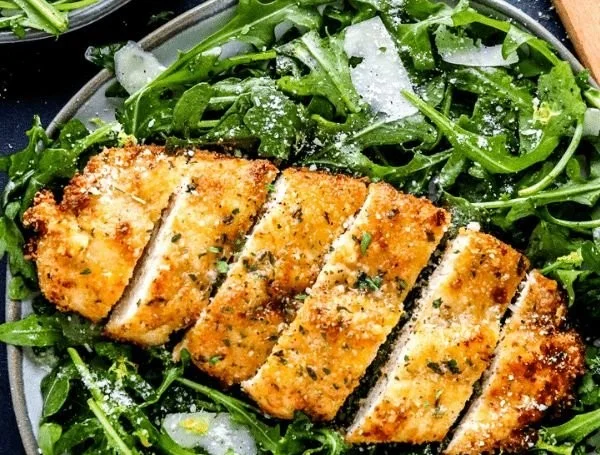 Crispy air fryer breaded chicken breast served with a side of vegetables.