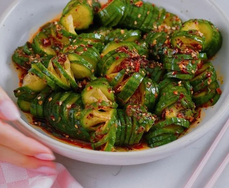 Bowl of Asian spicy cucumber salad garnished with sesame seeds and chili