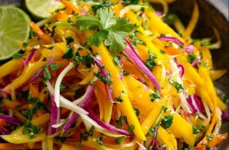 Colorful mango slaw in a bowl, perfect for summer dishes and parties.