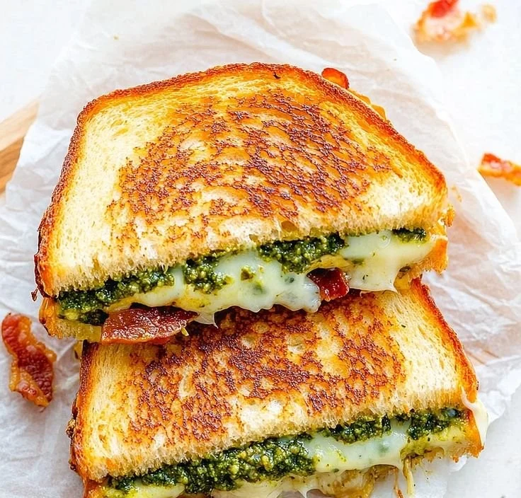 Delicious pesto grilled cheese sandwich with melted cheese and fresh pesto.