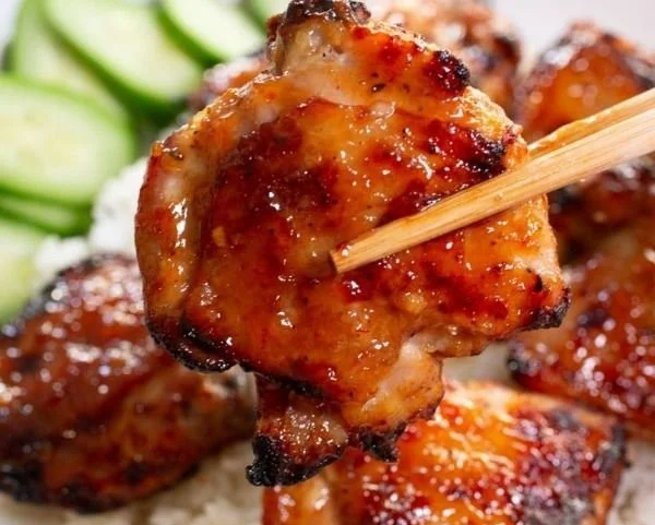 Sticky Sweet Chili Chicken Thighs cooked in an air fryer, garnished with herbs