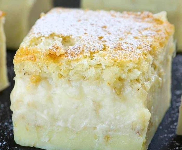 Slice of easy banana magic cake topped with fresh bananas and whipped cream.