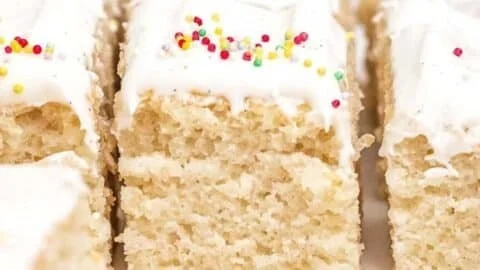 Delicious slice of easy vanilla cake with frosting on a white plate