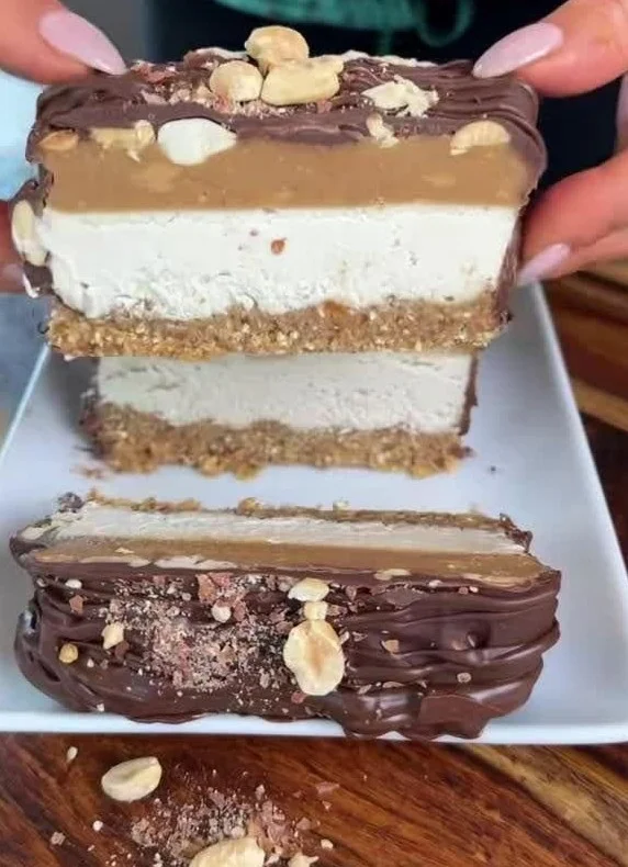 Healthy vegan Snickers Ice Cream Cake topped with chocolate and peanuts