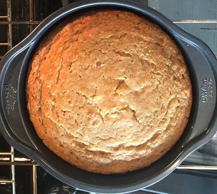 Delicious vegan vanilla cake topped with frosting and fresh berries.