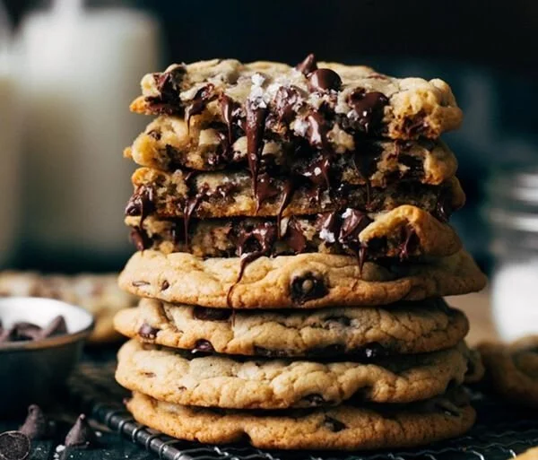 Freshly baked chocolate chip cookies on a cooling rack.