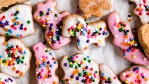 Baked frosted animal crackers displayed on a colorful plate.