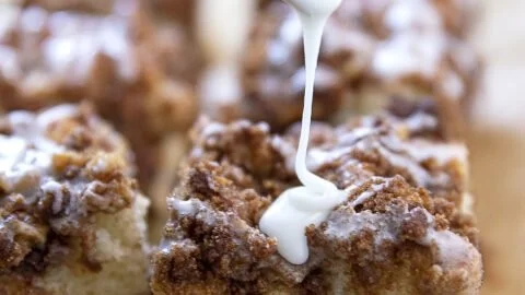 A freshly baked coffee cake with a crumbly topping served on a plate