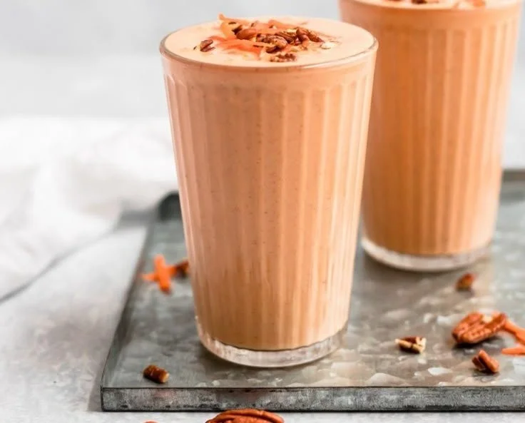 Creamy carrot cake smoothie topped with cinnamon and walnuts in a glass