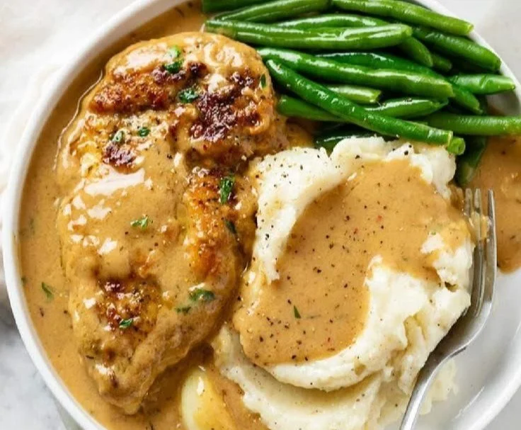 Delicious creamy garlic butter chicken served on a plate with herbs.