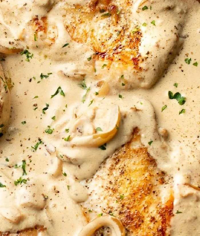 Creamy sour onion chicken dish served with vegetables on a plate