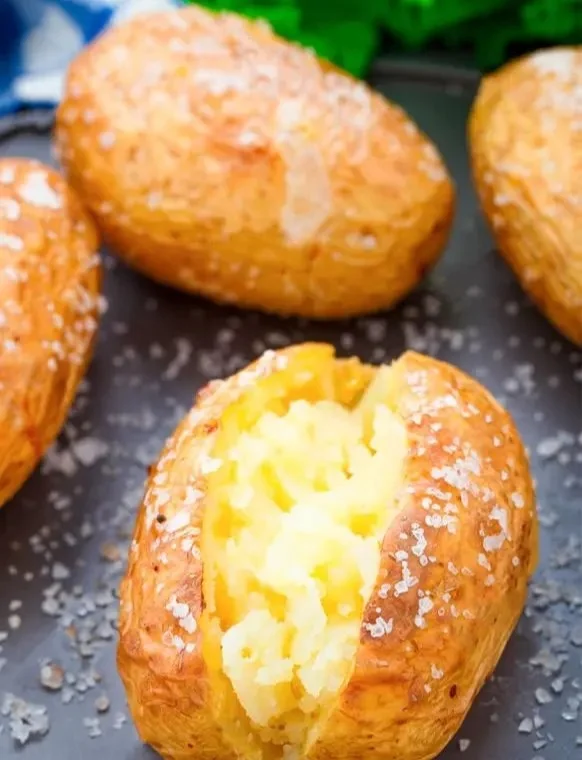 Crispy air fryer baked potatoes served on a plate with toppings