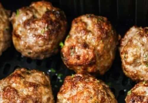 Crispy air fryer meatballs served on a plate with dipping sauce.