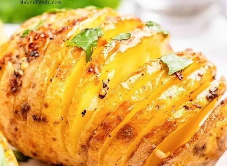 Crispy Hasselback Potatoes garnished with garlic and herbs