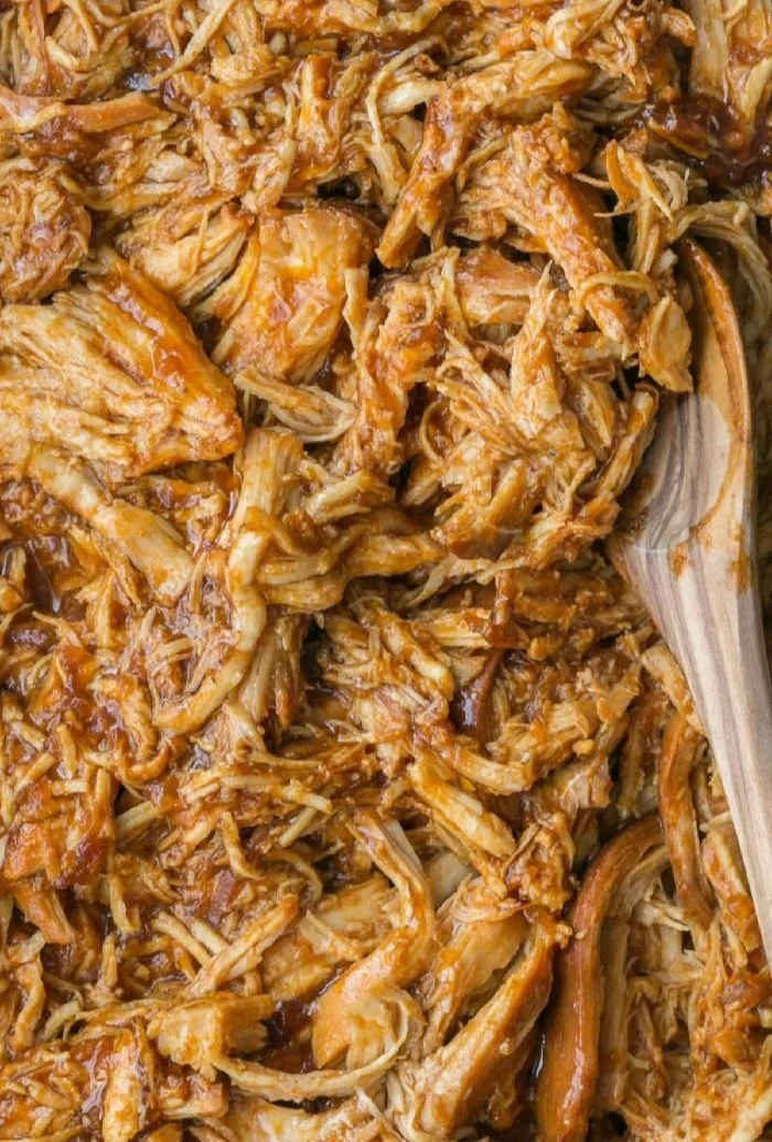 Delicious crockpot BBQ chicken served with sauce on a plate