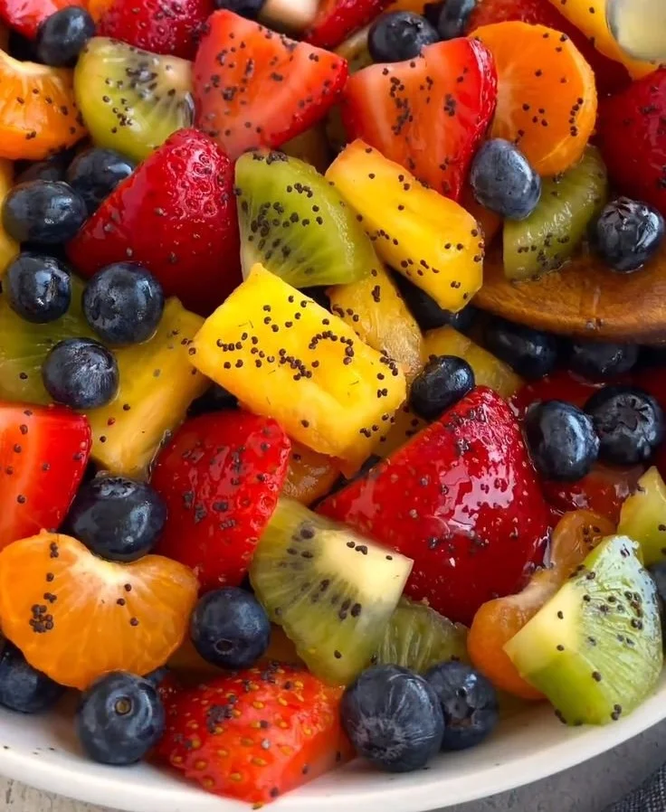 Bowl of fresh honey lime fruit salad with colorful fruits and a drizzle of honey