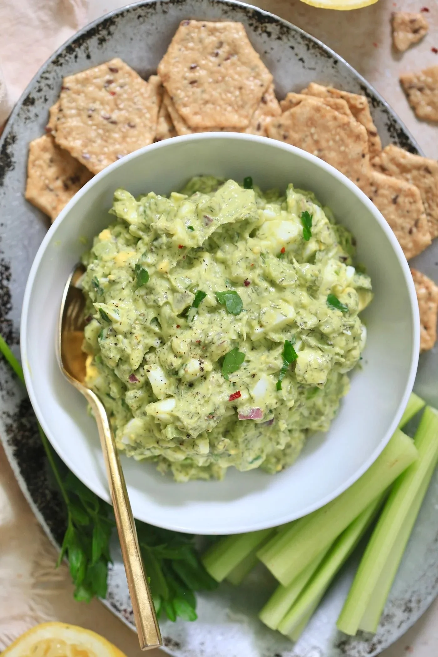 Herby avocado egg salad topped with fresh herbs and served in a bowl
