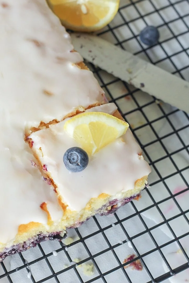 Delicious lemon blueberry sheet cake topped with fresh blueberries and lemon zest