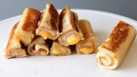 Delicious melted cheese roll-ups on a plate, perfect for a quick snack.