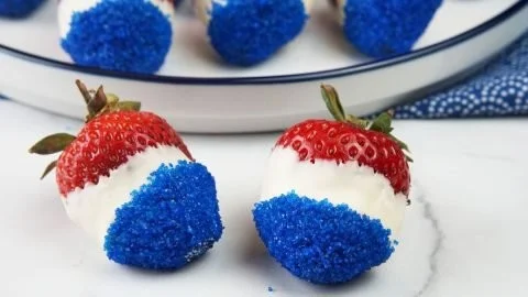Patriotic white chocolate dipped strawberries with red, white, and blue sprinkles