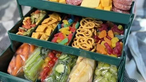 Colorful charcuterie snack tray with assorted cheeses, meats, and fresh fruits.