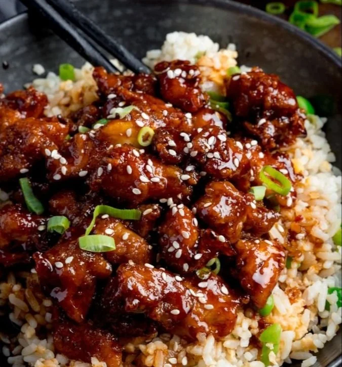 Delicious sesame chicken cooked in an air fryer, served on a plate.