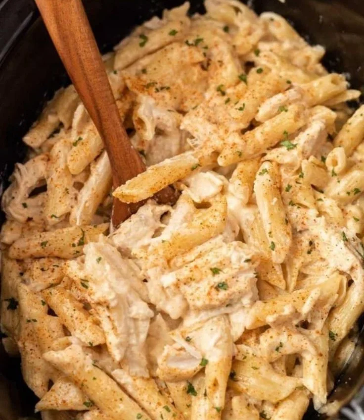 Cajun slow cooker chicken pasta topped with fresh herbs and spices