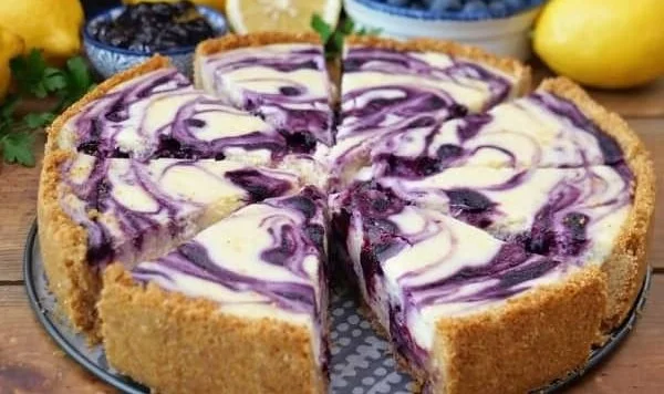 Slice of creamy lemon blueberry cheesecake topped with fresh blueberries