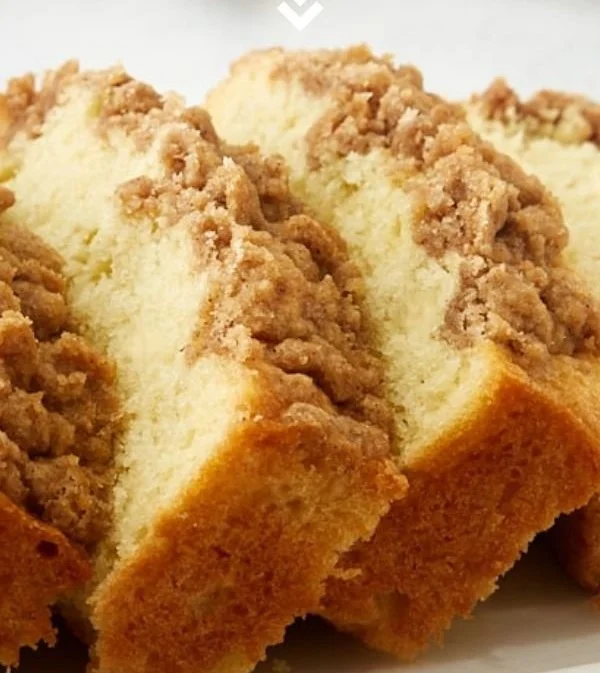 Slice of creamy sour cream coffee cake with a golden crumb topping