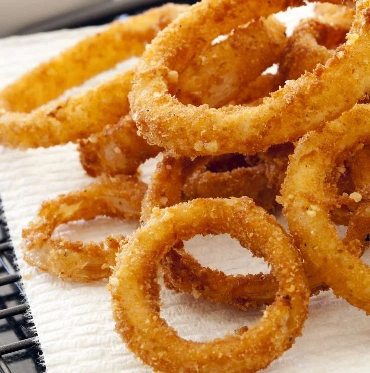 Crispy air fryer onion rings served with dipping sauce.