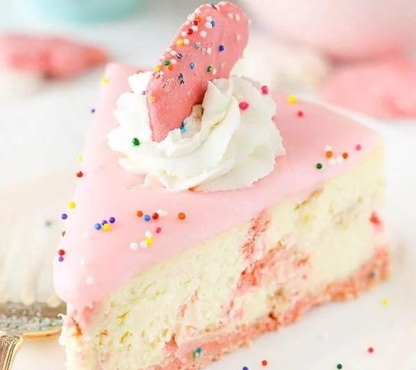 Delicious Frosted Animal Cookie Cheesecake topped with colorful animal cookies