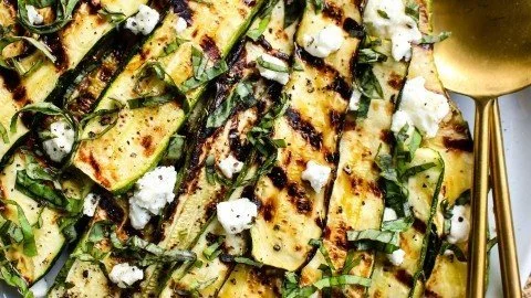 Delicious grilled zucchini topped with creamy goat cheese, perfect for summer grilling.