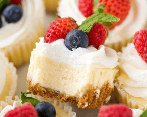 Delicious mini cheesecakes topped with fruit on a decorative plate.