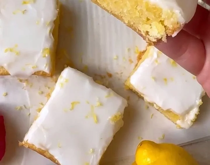 Delicious lemon brownies with a zesty glaze on a white plate