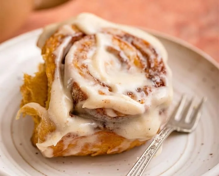 Delicious homemade pumpkin cinnamon rolls topped with cream cheese icing