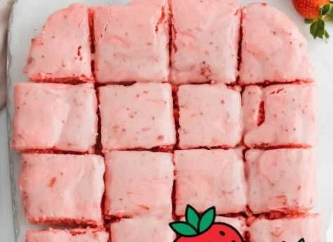 Delicious strawberry brownies with creamy frosting on a white plate