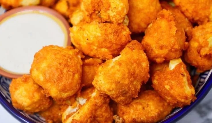 Air fryer buffalo cauliflower bites served in a bowl with dipping sauce