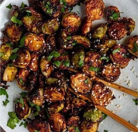 Asian BBQ Brussels sprouts garnished with spices and herbs
