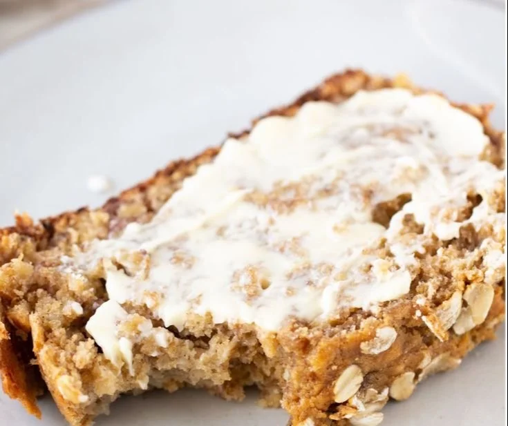 Freshly baked banana oatmeal bread topped with slices of banana