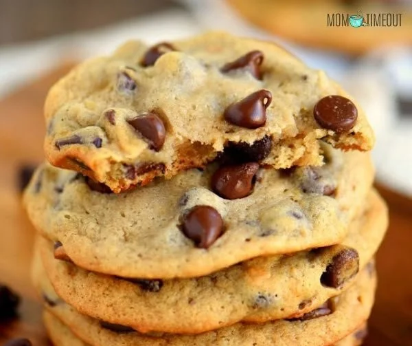 Baked chocolate chip banana cookies on a plate with chocolate chips and bananas
