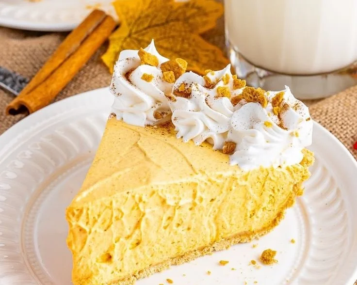 No-bake pumpkin cheesecake topped with whipped cream and spices