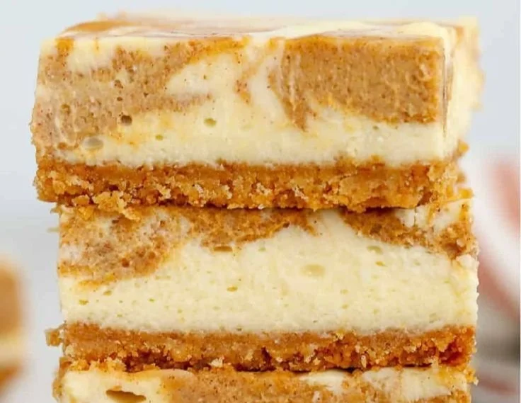 Delicious creamy pumpkin cheesecake bars topped with whipped cream
