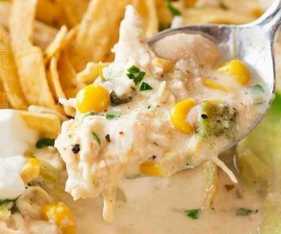 Bowl of creamy white chicken chili garnished with cilantro and lime.