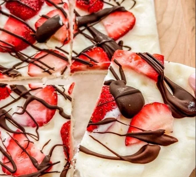 Dark chocolate strawberry yogurt bark topped with fresh strawberries and yogurt