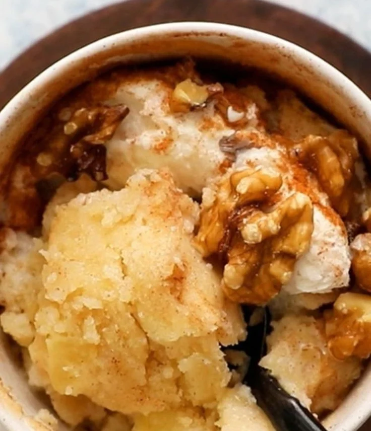 Easy apple mug cake in a white mug with a slice of apple