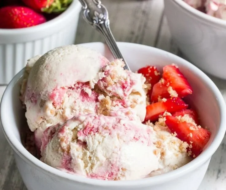 Healthy strawberry ice cream served in a bowl with fresh strawberries on top.
