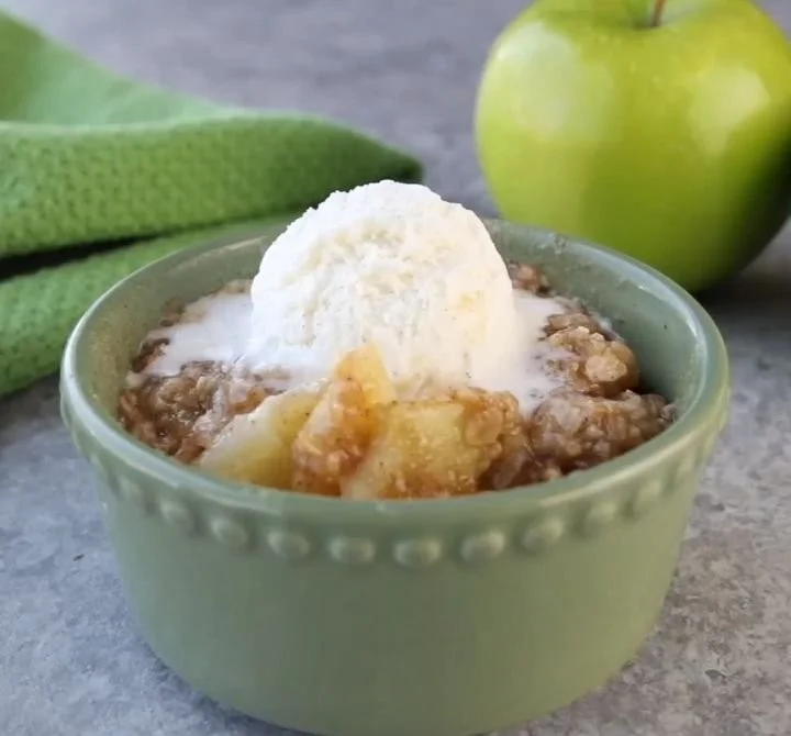 Single serving of homemade apple crisp served in a bowl with a scoop of ice cream