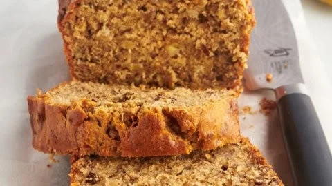 Slices of moist peanut butter banana bread on a wooden table
